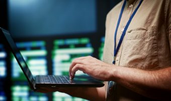 Technicien ou administrateur système gérant des infrastructures sécurisées sur un ordinateur portable.